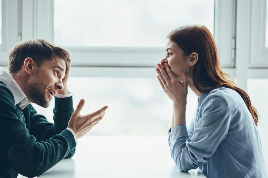 Gespräch zwischen Frau und Mann. Mann übertreibt eine Aussage, um ein Argument zu schwächen. Darstellung des Strohmann-Arguments.