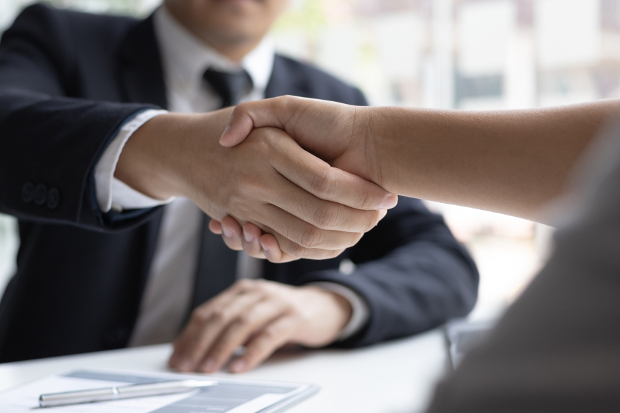 Mitarbeiter bei der Vertragsunterzeichnung mit Handshake am Ende