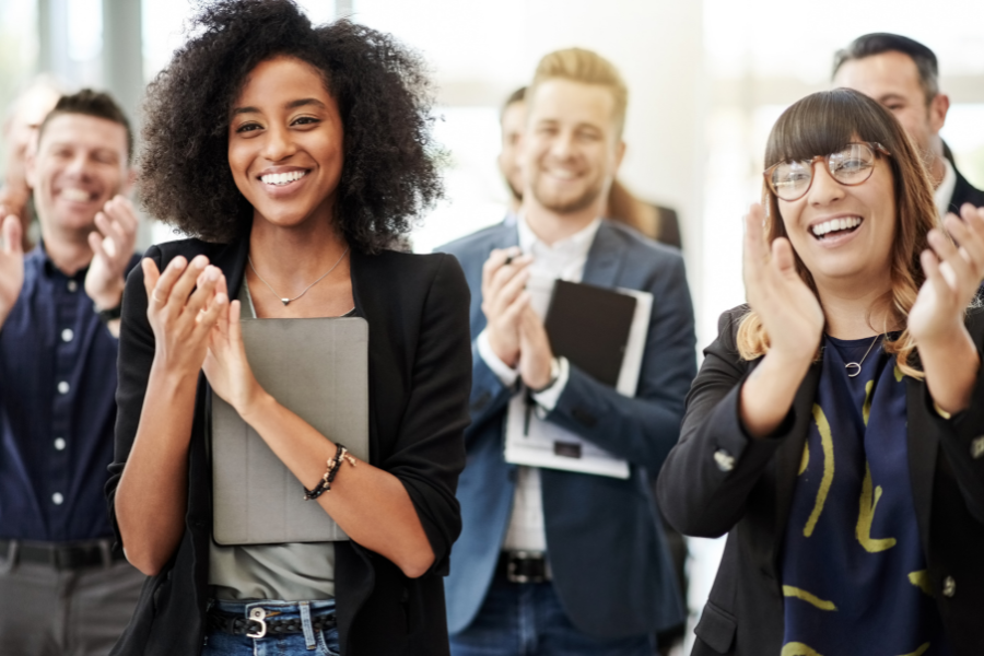 Mitarbeiter:innen applaudieren dem Unternehmen zur neuen Employer Branding Strategie mit ethisch korrekter Denkweise