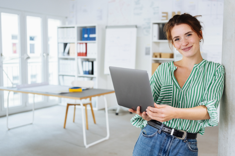 Frau mit Laptop im Büro beim Antrag eines Skills Scheck als Förderung für Ihren Diplomkurs KI in Marketing und Kommunikation der eLearning Academy for Communication