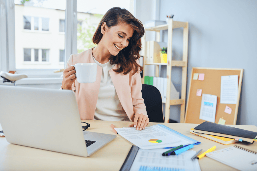 Frau mit Kaffeebecher beim Studieren