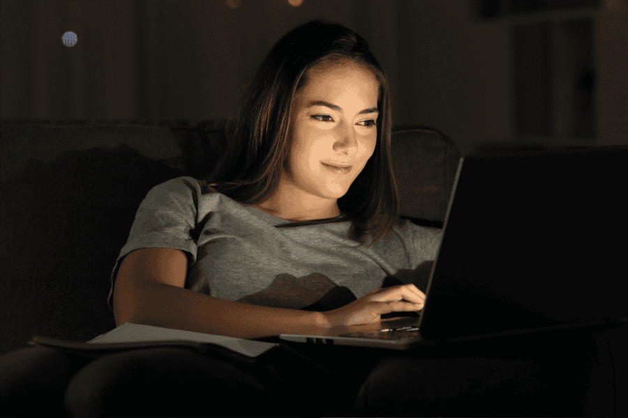 Frau mit Laptop lernt nachts führ ihren MBA in Eventmanagement